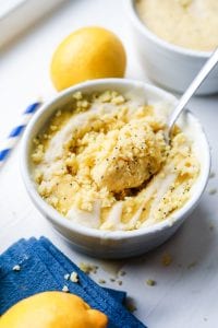 A fork about to take a piece of lemon cake out of a mug.