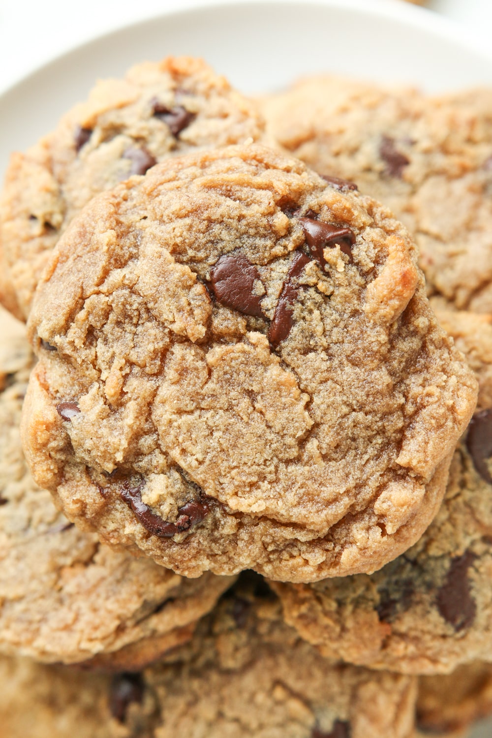 A chocolate chip cookie on top of other chocolate chip cookies.