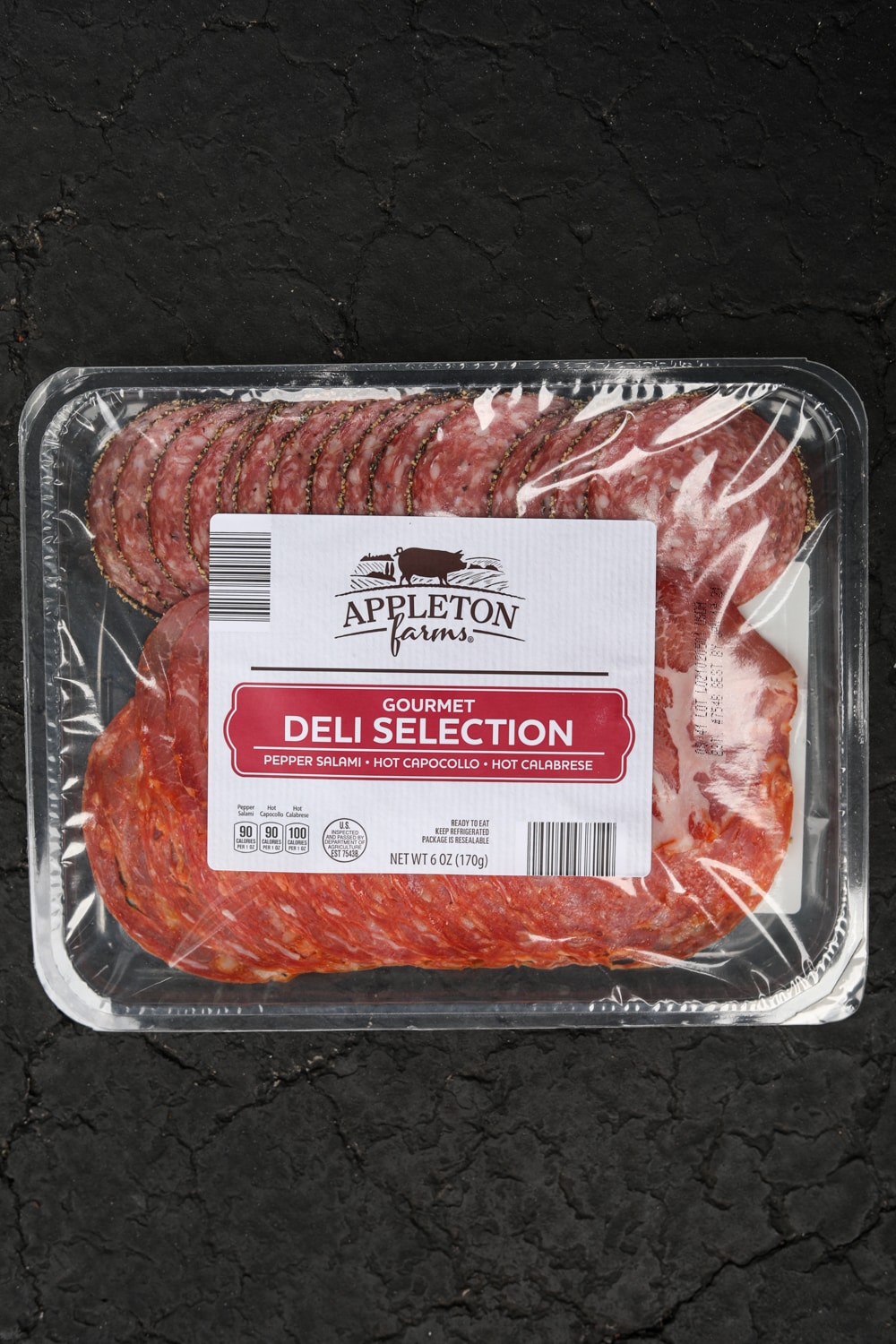 A container with an assortment of deli pepperoni.