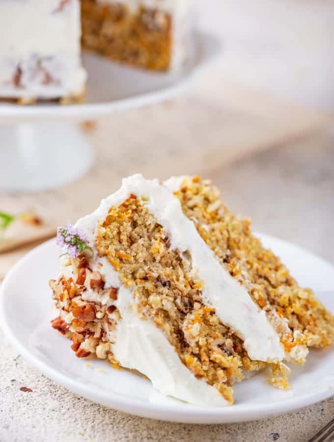 A slice of carrot cake on a white plate.