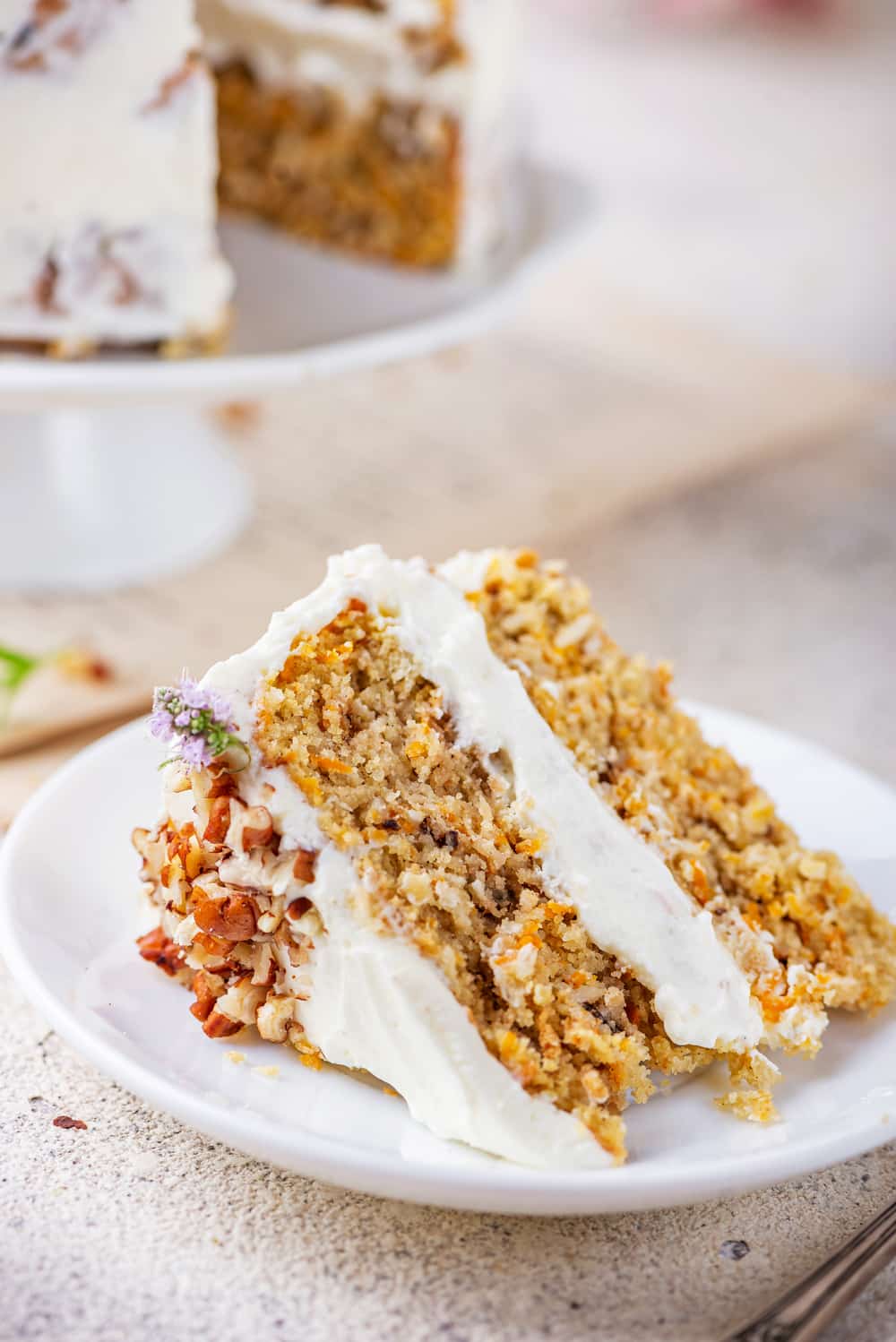 A slice of carrot cake on a white plate.