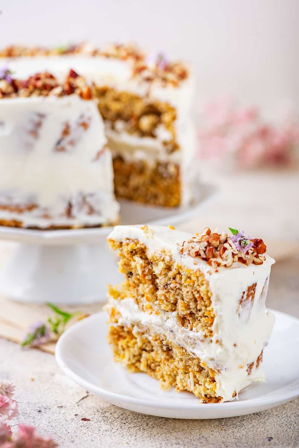 A slice of carrot cake that has just been served to a plate.