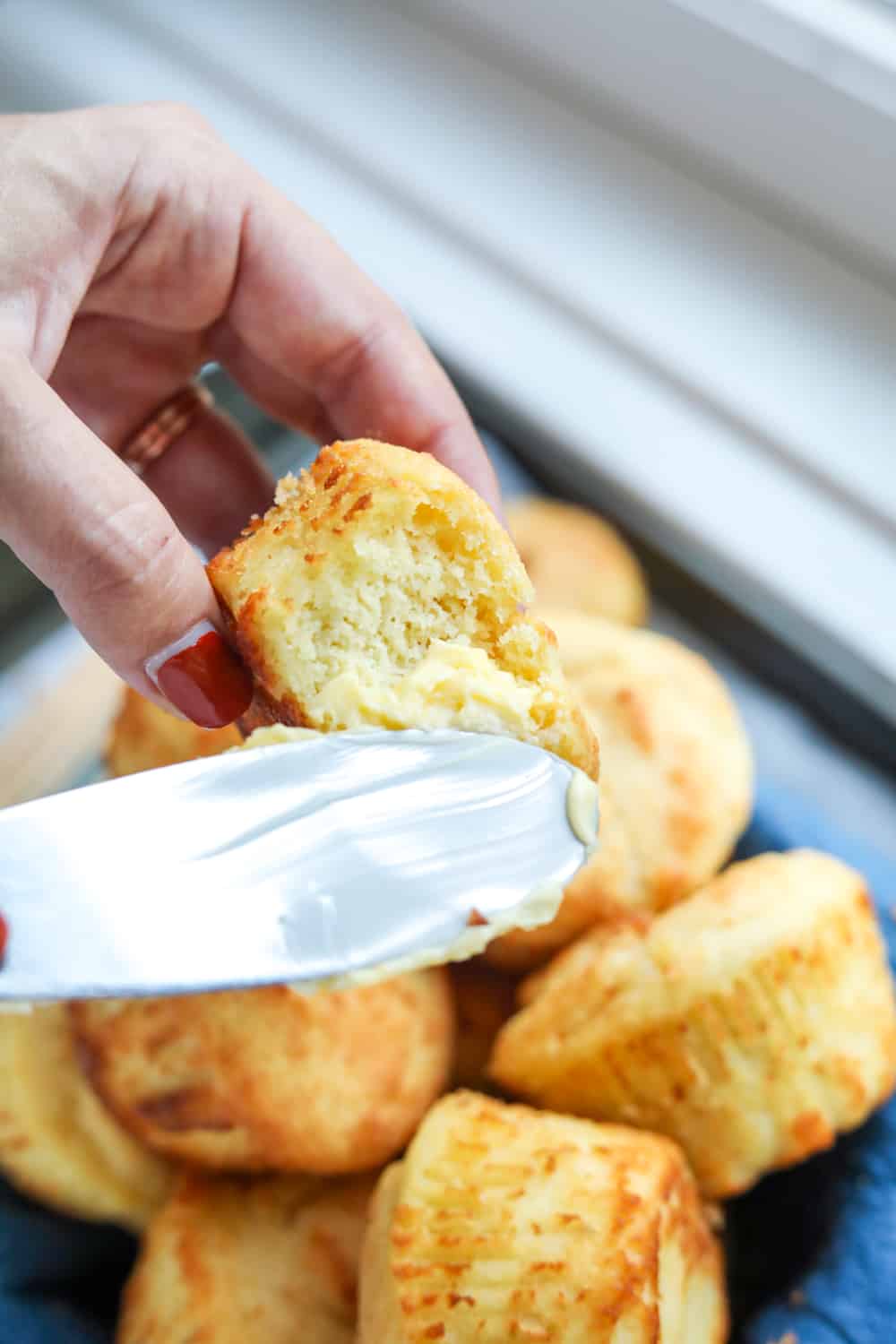 A butter knife spreading butter on a biscuit.