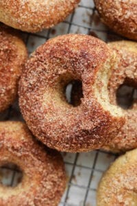 A donut with a bite taken out of it on top of other donuts.