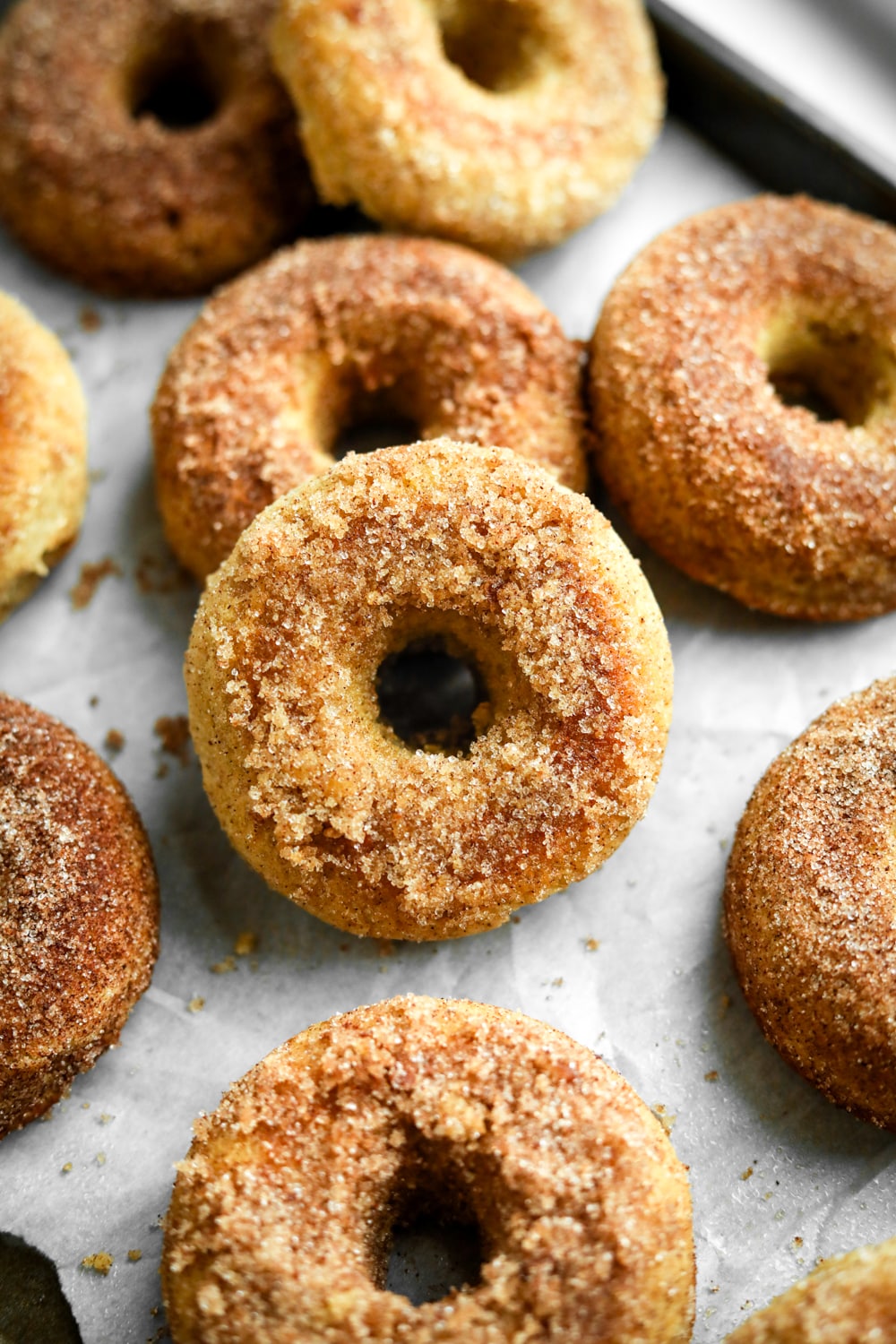 Donuts on a baking sheet lined with parchment paper.