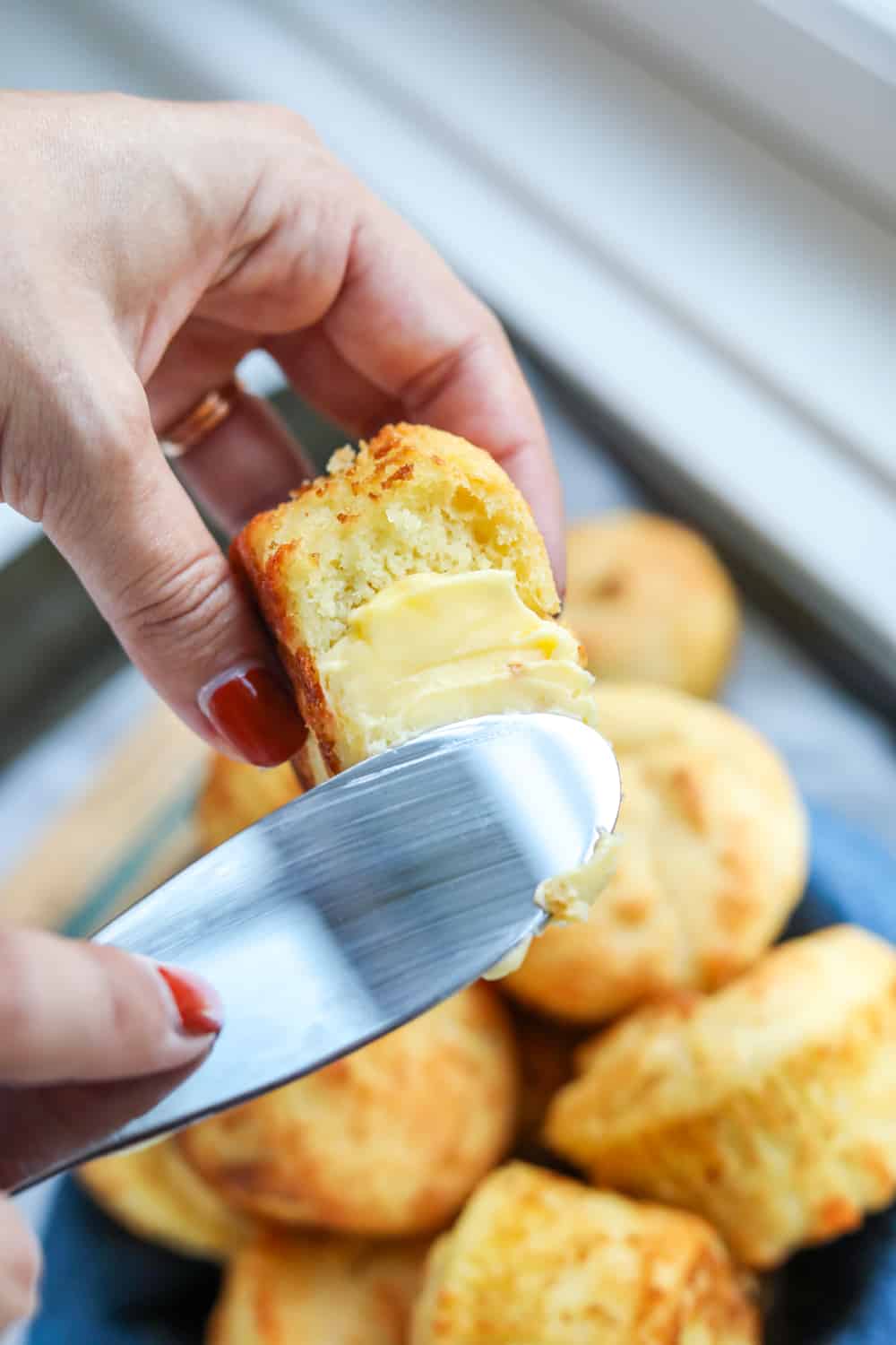 Butter being spread on a biscuit.