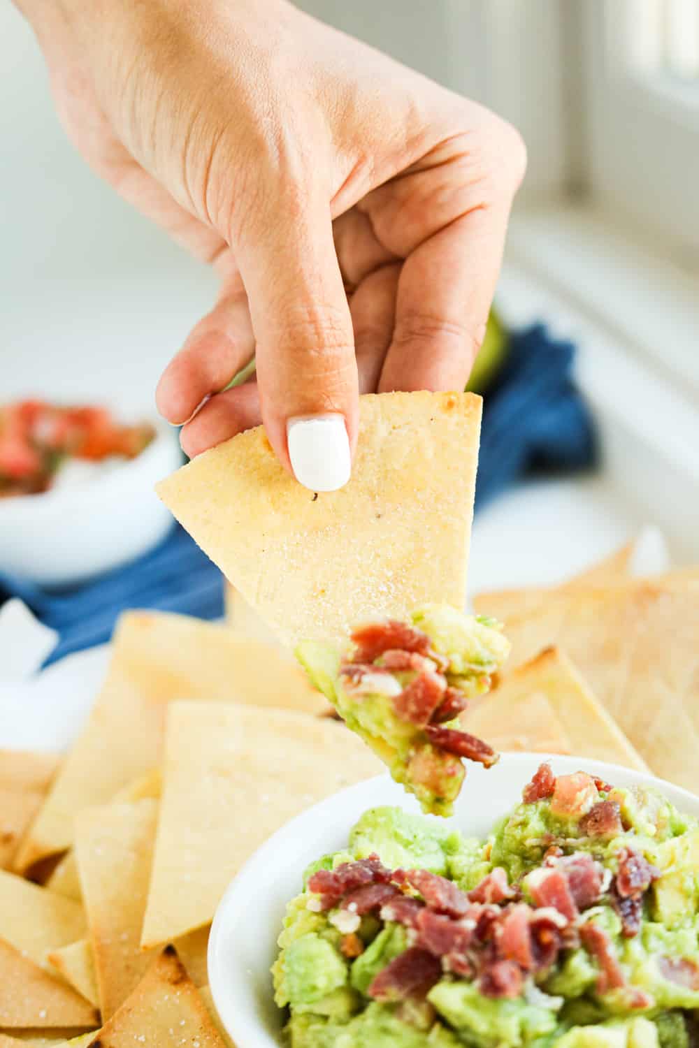 A tortilla chip topped with guacamole.