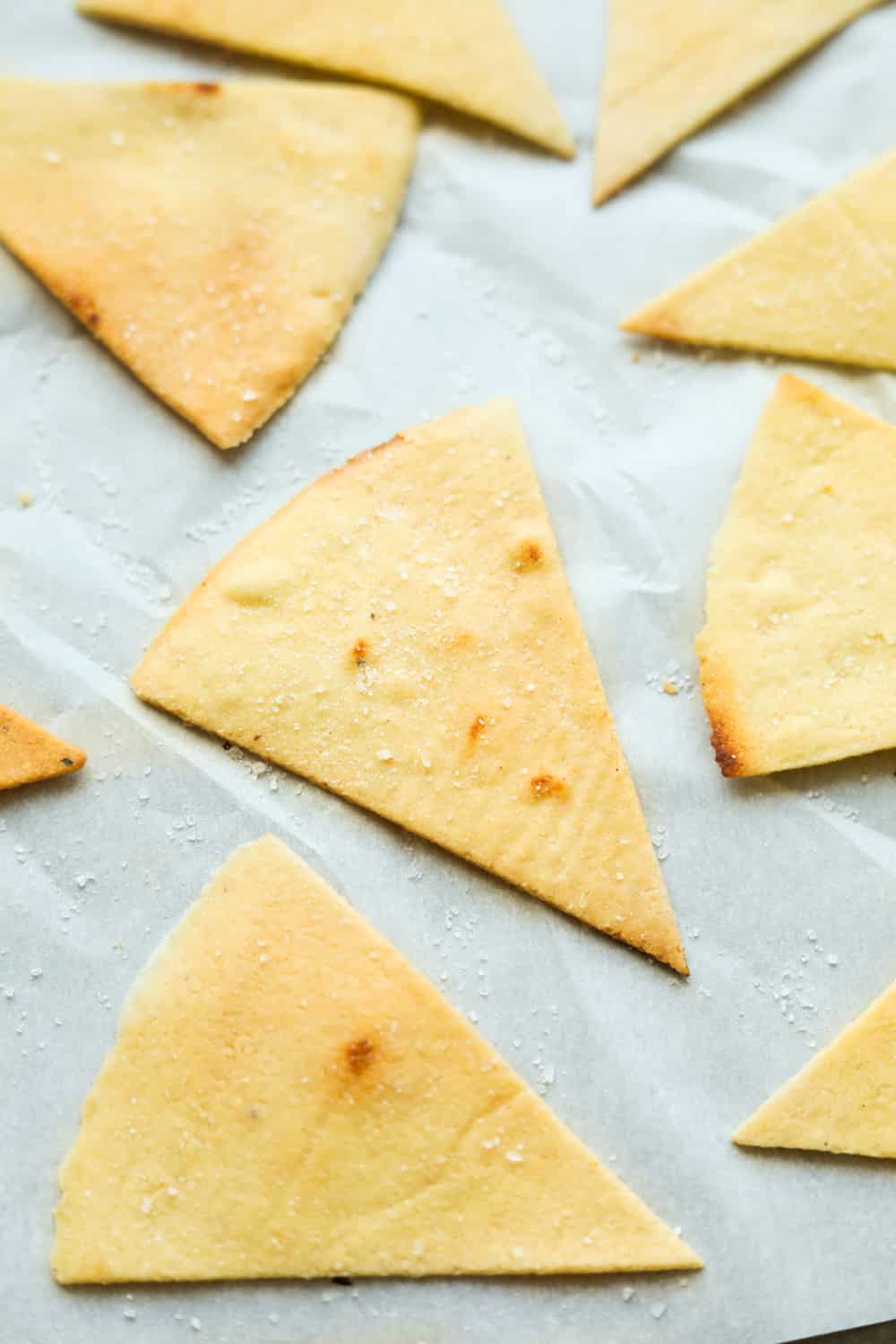 Tortilla chips on white parchment paper.