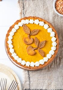 A pumpkin pie set on top of a tan napkin.