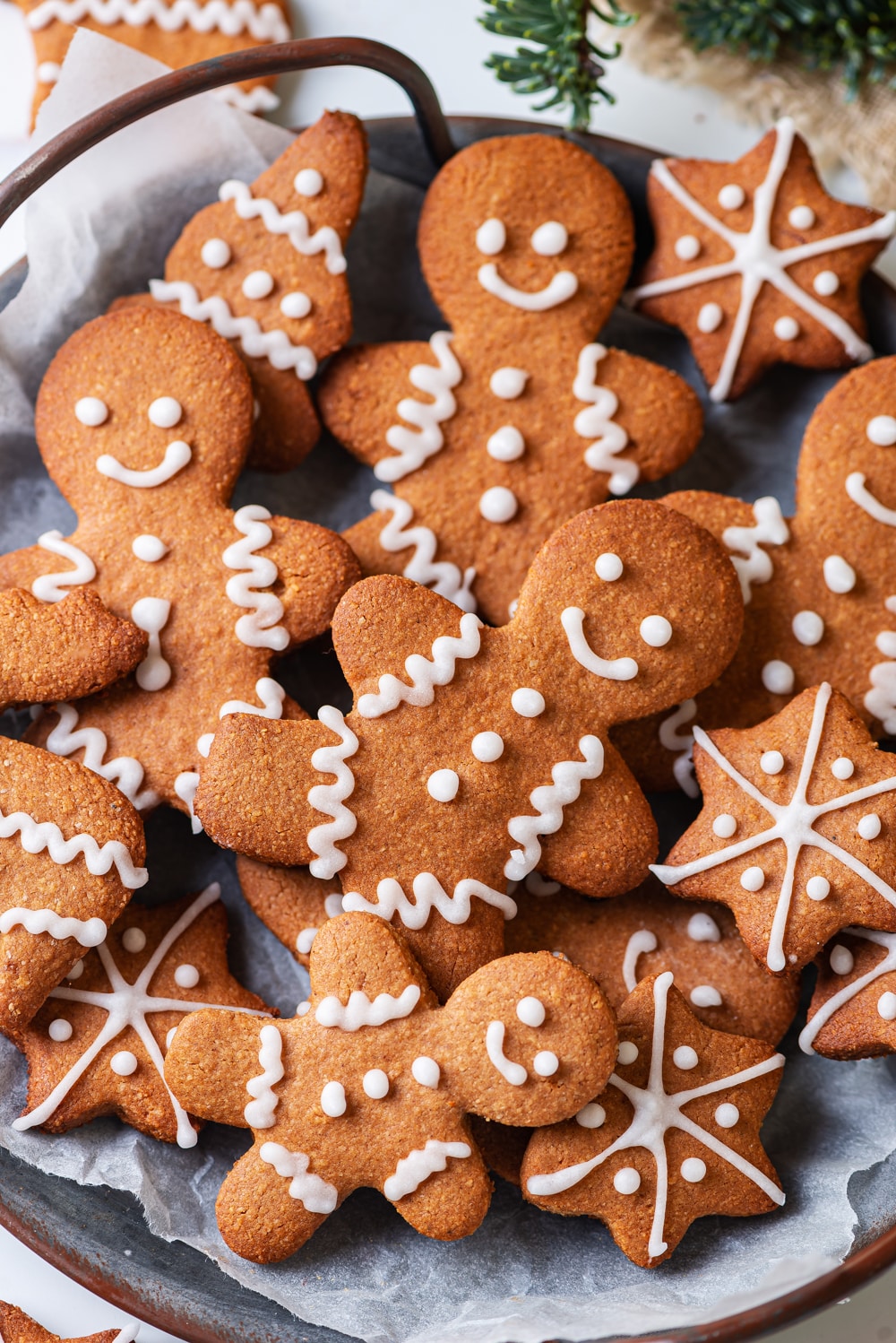 Gingerbread cookies on top of parchment paper on a grey plate.