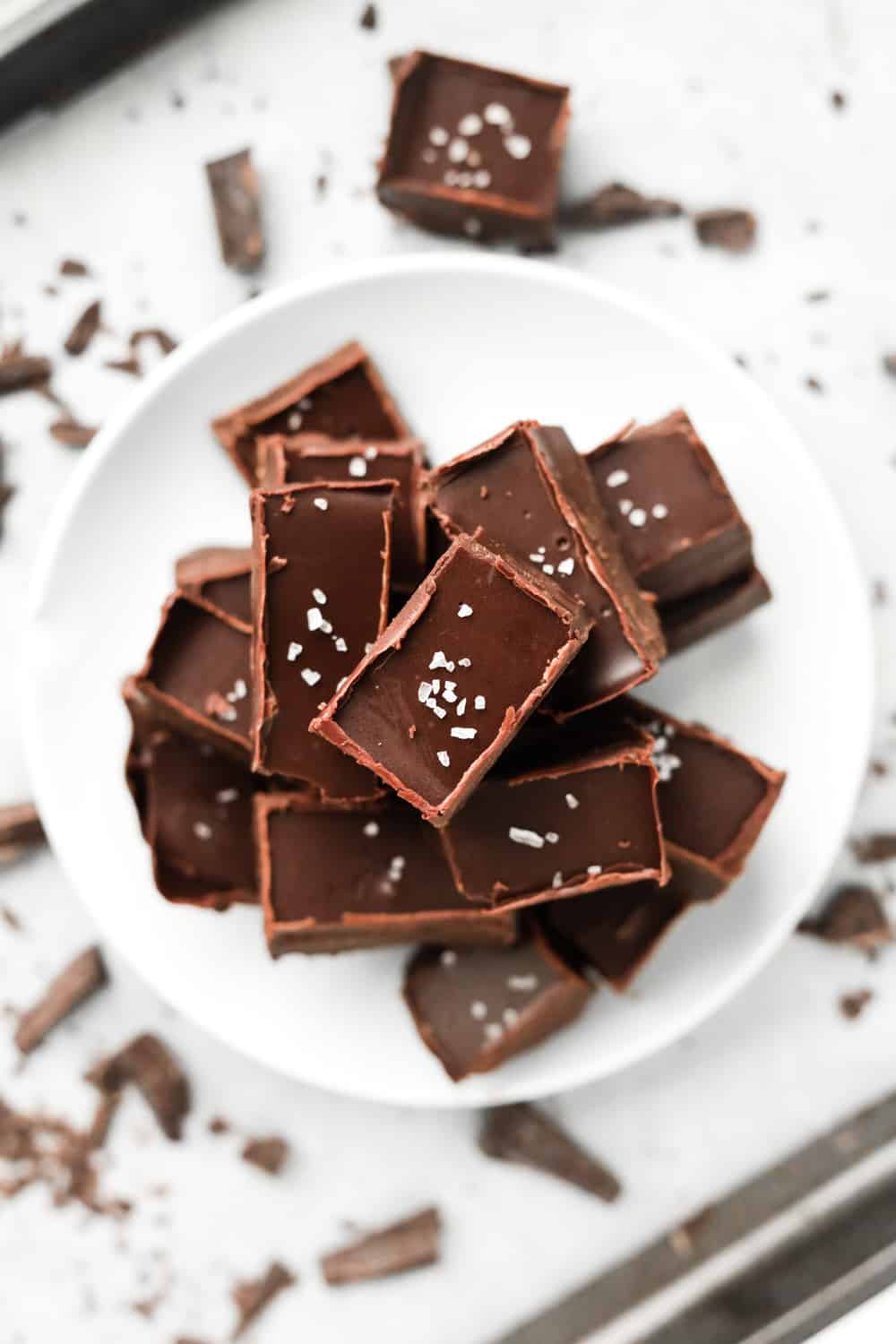 A pile of fudge on a white plate.