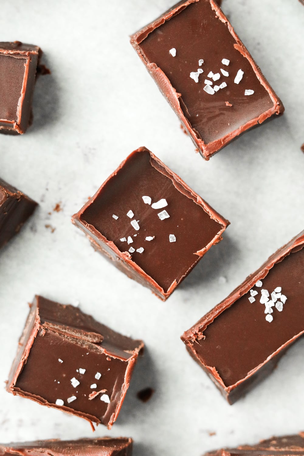 Pieces of chocolate fudge on a sheet of white parchment paper.