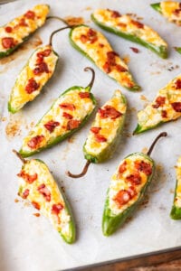 Jalapenos filled with cheese and topped with bacon.