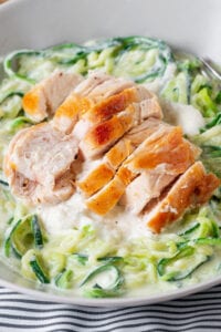 Zucchini noodles topped with alfredo sauce and chopped chicken.