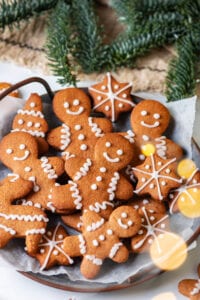 A plate full of gingerbread cookies on white parchment paper.