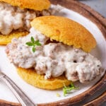 A biscuit and gravy sandwich on a plate.