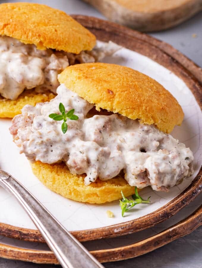 A biscuit and gravy sandwich on a plate.