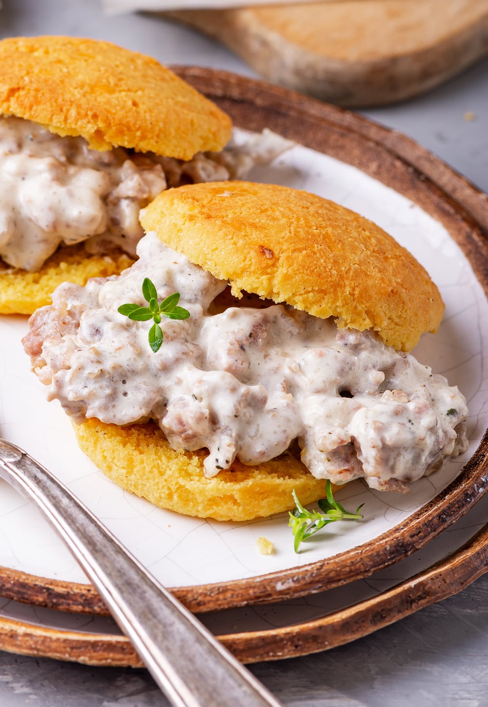 A biscuit and gravy sandwich on a plate.