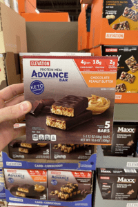 A hand holding a box of meal replacement bars.