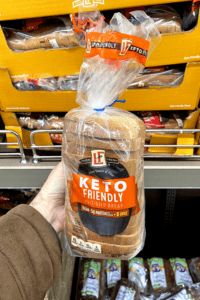 A hand holding a loaf of keto bread.