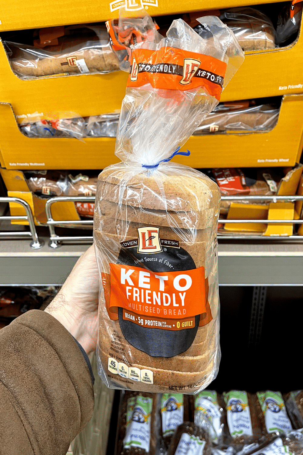 A hand holding a loaf of keto bread.