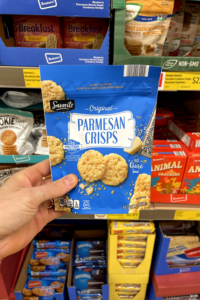 A hand holding a bag of parm crisps.