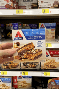 A hand holding a box of peanut butter fudge crisp bars.