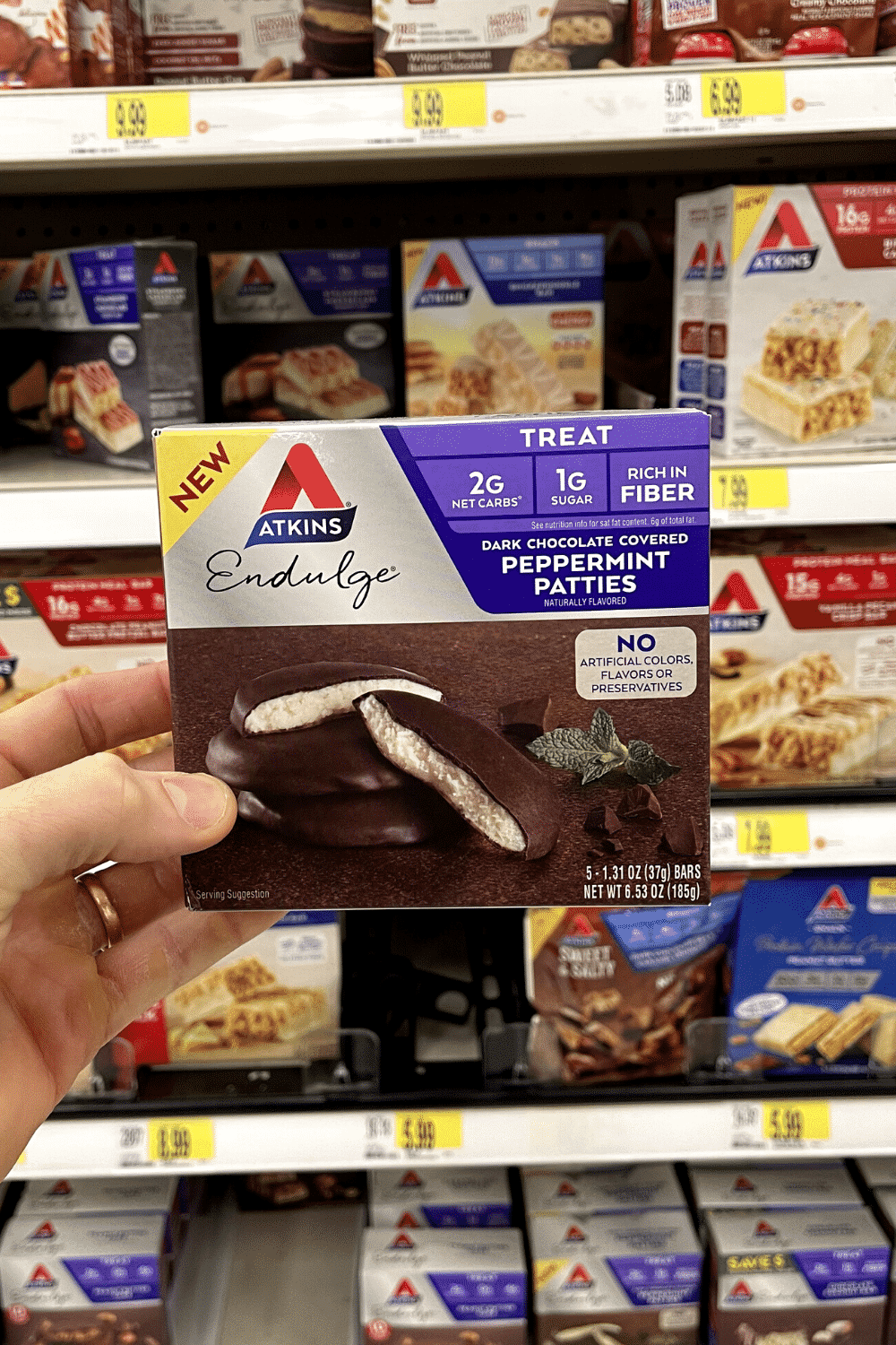 A hand holding a box of low carb peppermint patties.