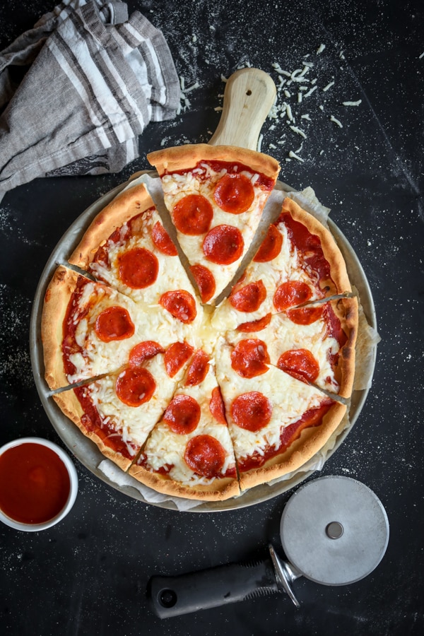 A pizza cut into 8 slices. The pizza is on top of a cutting board.