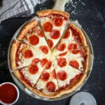 A pizza cut into 8 slices. The pizza is on top of a cutting board.