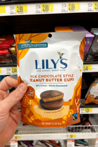 A hand holding a bag of low carb milk chocolate peanut butter cups.
