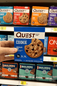 A hand holding a box of low carb chocolate chip cookies.