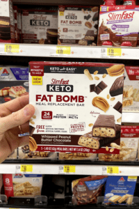 A hand holding a box of keto meal replacement bars.