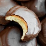 A chocolate covered cookie with a bite taken out of it.