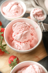 A white bowl filled with strawberry ice cream