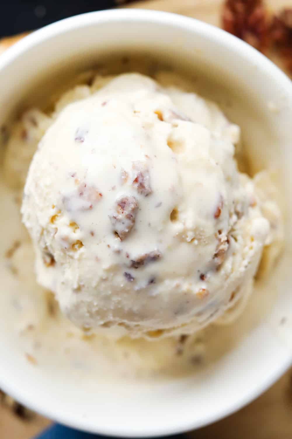 A scoop of ice cream in a white bowl.