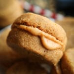 A peanut butter cookie that is placed on top of other peanut butter cookies.