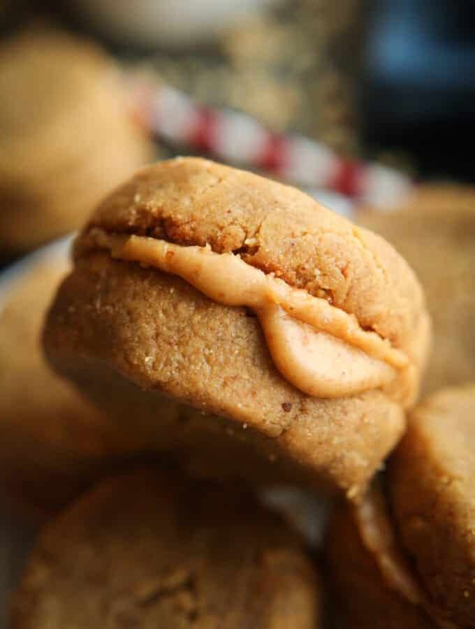 A peanut butter cookie that is placed on top of other peanut butter cookies.