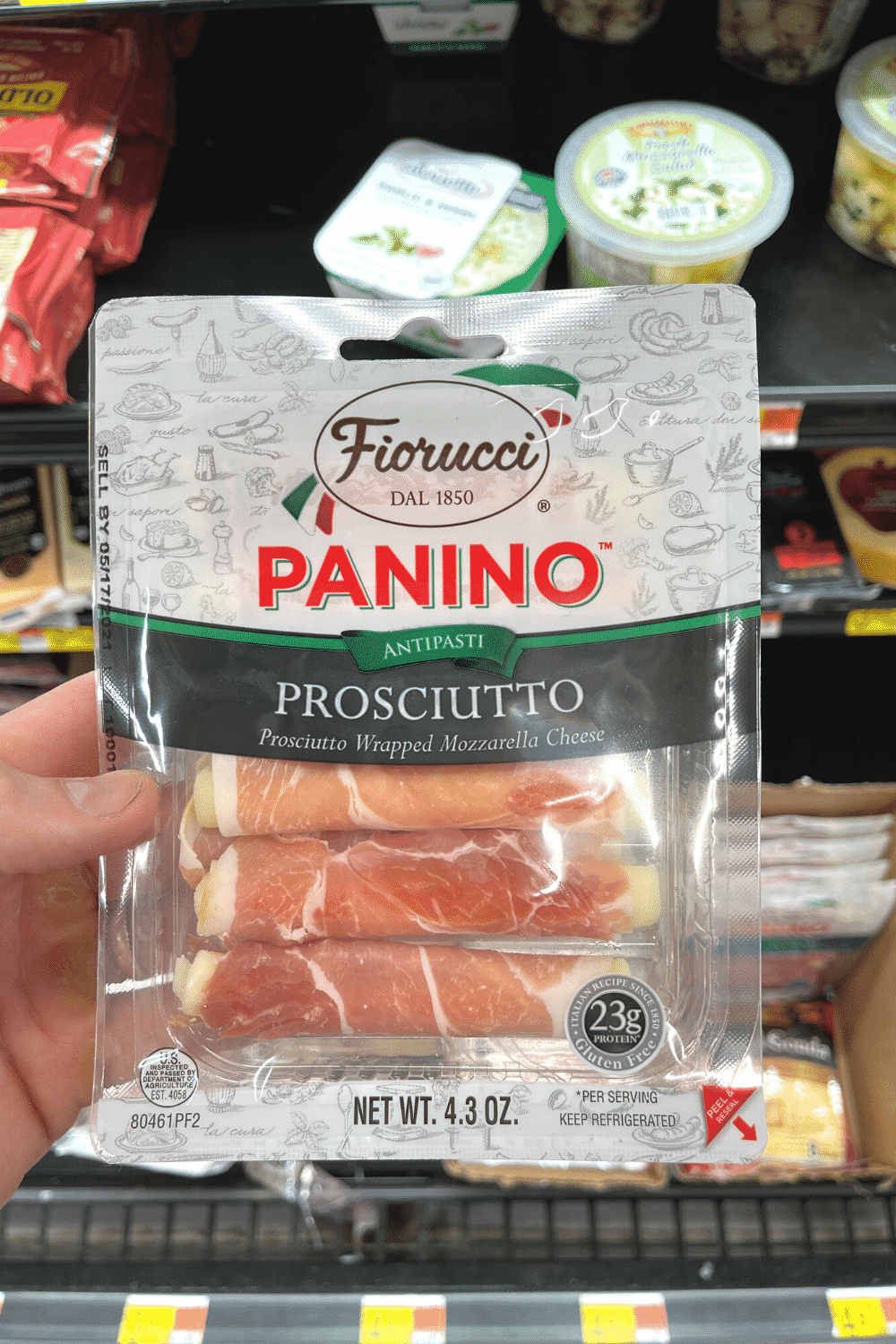 A hand holding a package of paninos.