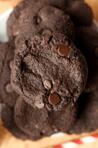 A stack of multiple chocolate cookies with chocolate chips.
