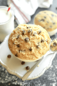 A white bowl filled with edible cookie dough. The bowl is on a white platter.