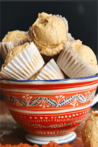 A bunch of pumpkin spice fat bombs in a white blue and orange striped bowl.