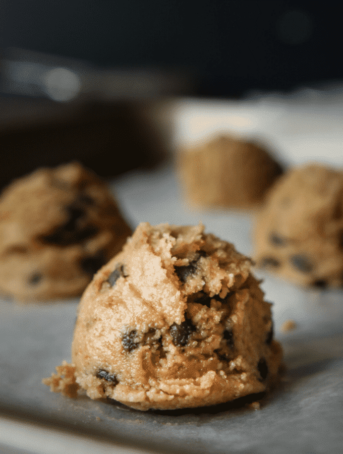 Peanut butter cookie dough fat bombs on a baking sheet.