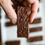 A hand holding a chocolate candy bar.