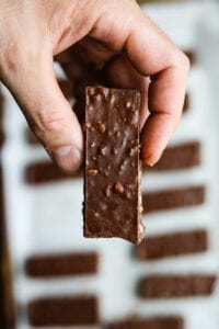 A hand holding a chocolate candy bar.