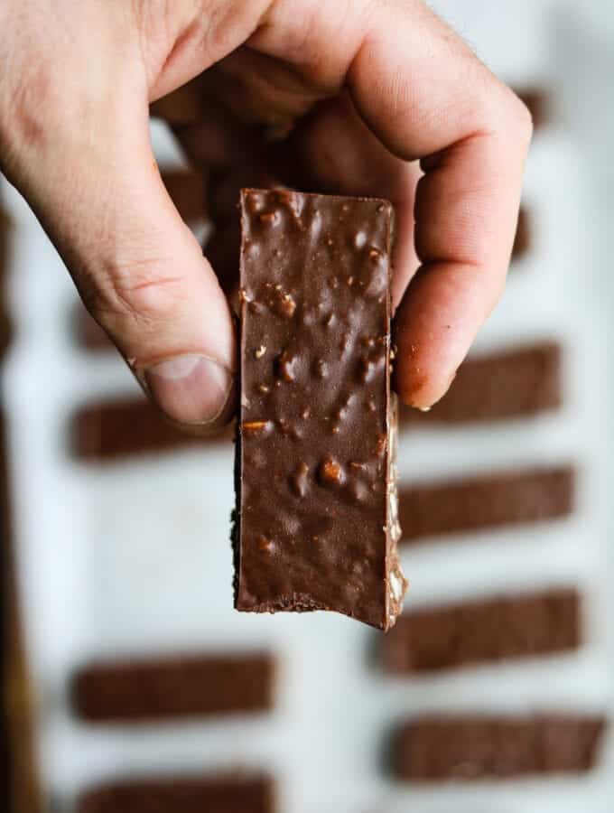 A hand holding a chocolate candy bar.