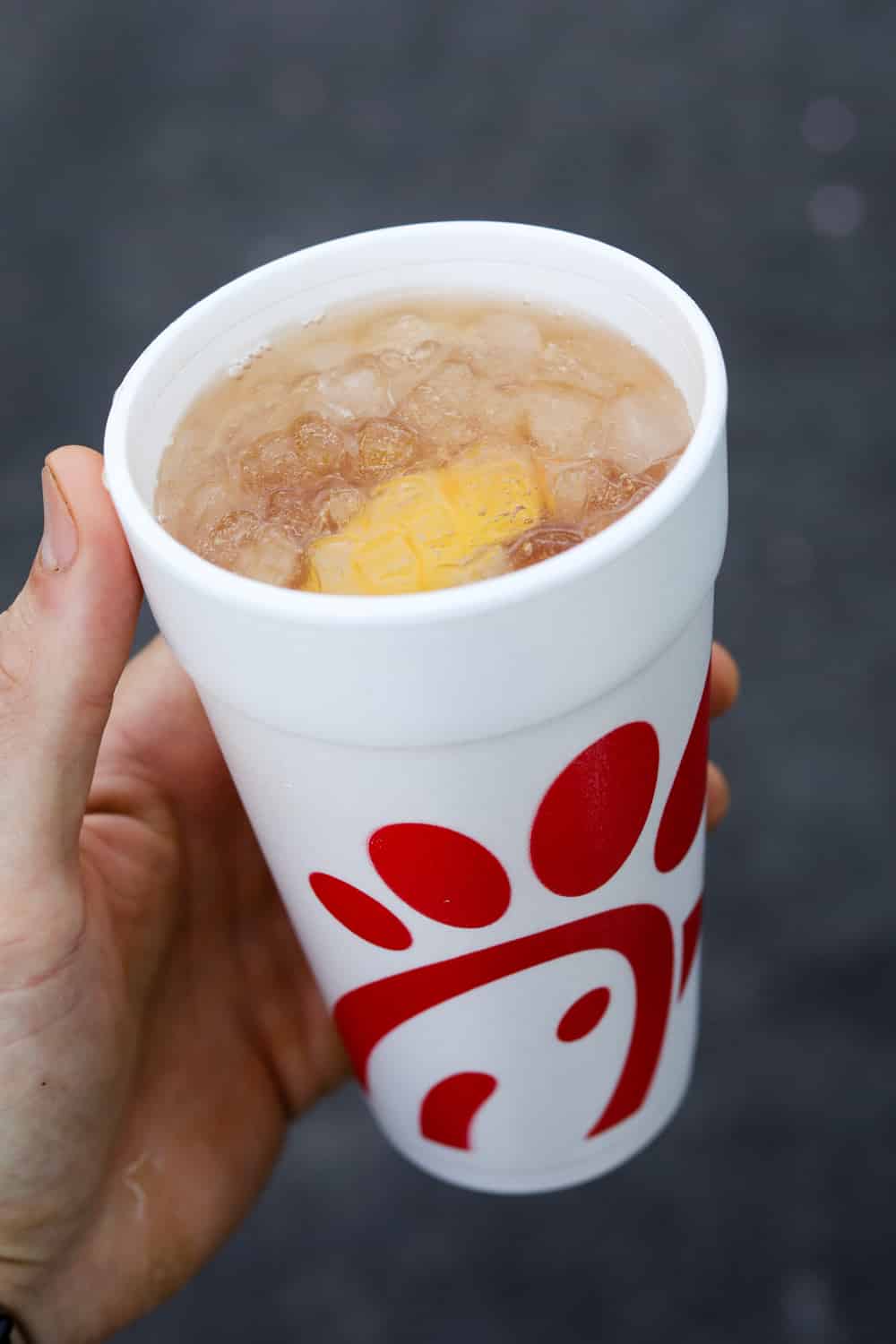 A hand holding a cup of diet Sunjoy from Chick-fil-A.