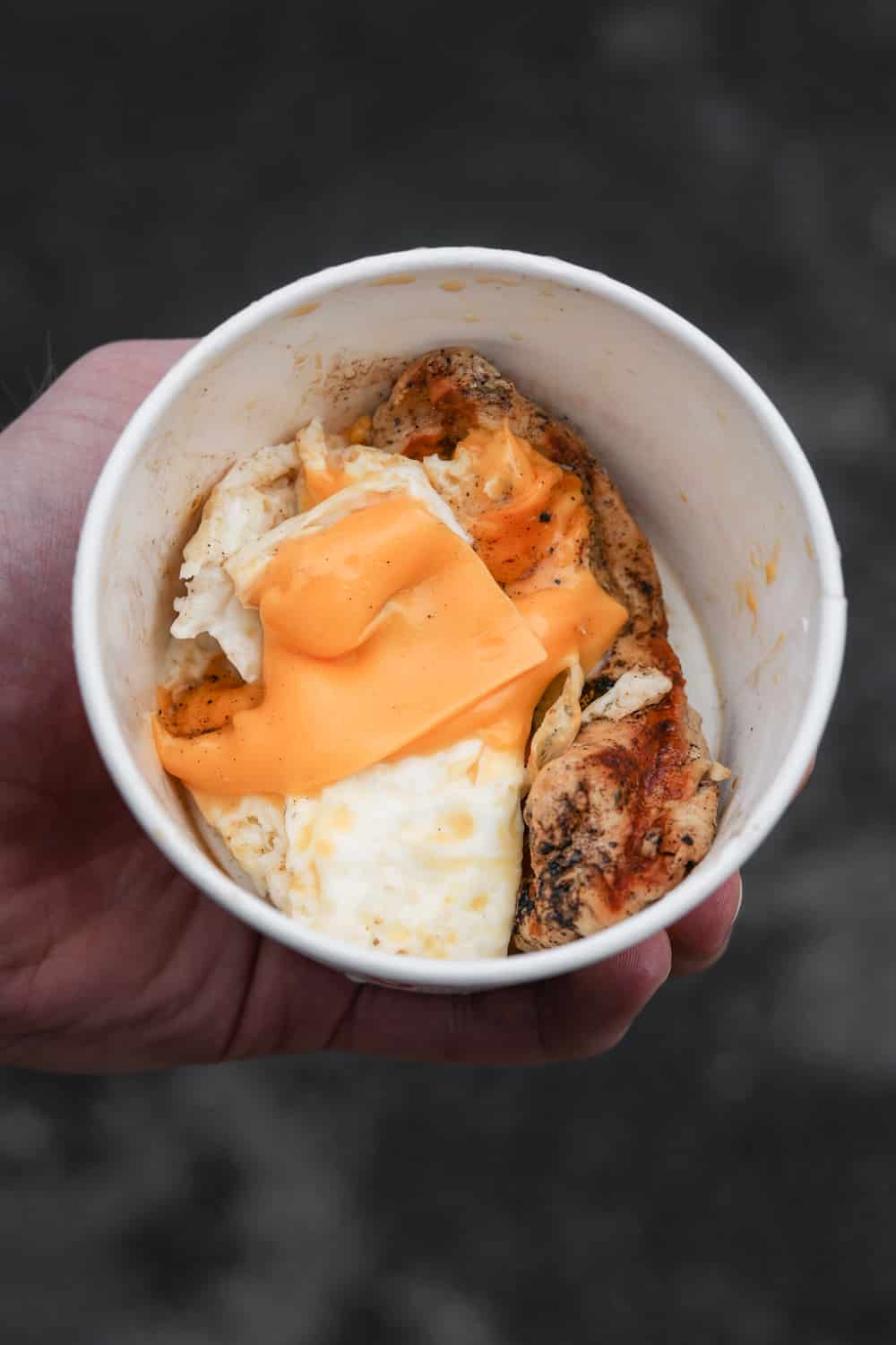 A hand holding a cup of keto egg white grill from Chick-fil-A.