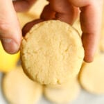 A hand holding a lemon cookie.