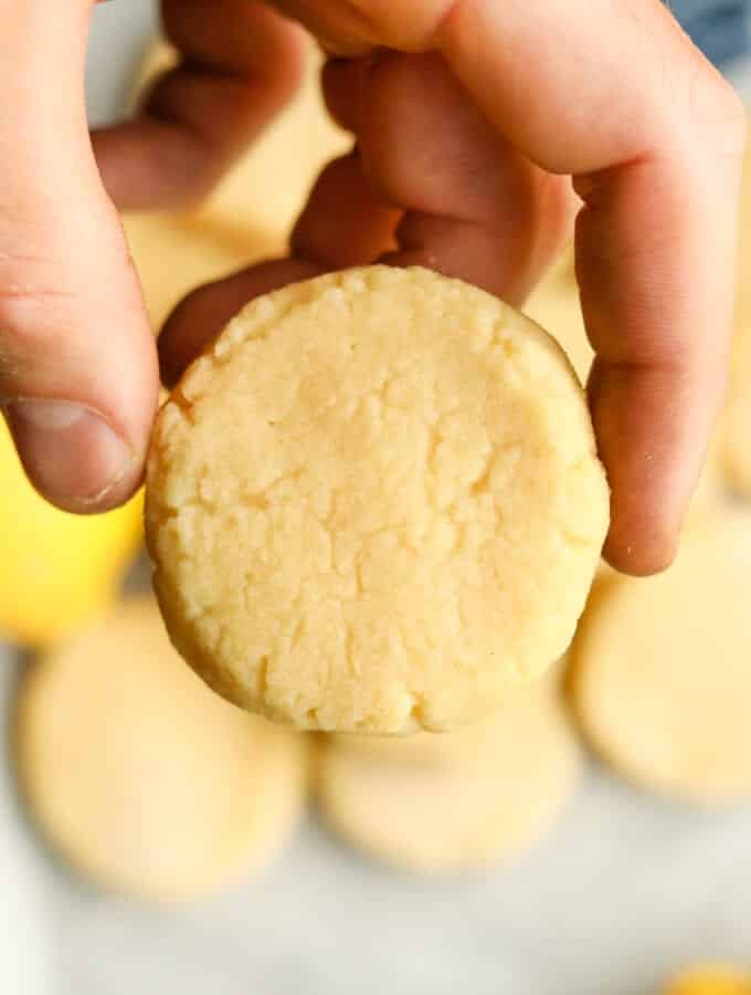 A hand holding a lemon cookie.